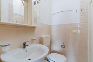 a bathroom with a white sink and a toilet at La casetta 461 in Torre San Giovanni Ugento