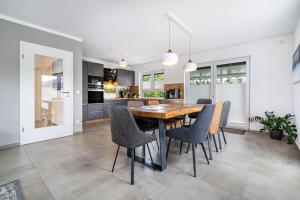 a kitchen and dining room with a wooden table and chairs at Seeglück 1 am Tollensesee in Groß Nemerow