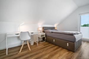 a bedroom with a bed and a desk and a chair at Seeglück 1 am Tollensesee in Groß Nemerow