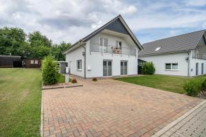 a large white house with a brick driveway at Seeglück 1 am Tollensesee in Groß Nemerow
