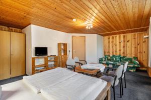 a room with two beds and chairs and a television at Bungalow 9 - Kimbucht in Reichendorf