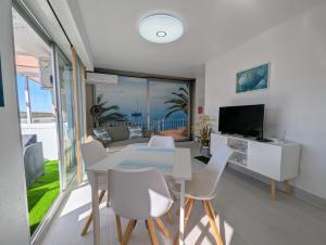 a living room with a table and chairs and a television at R-23 Modern apartment in La Mata in La Mata