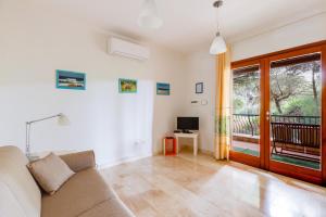 a living room with a couch and a television at Casa Antonella sul Golf in S'archittu Cuglieri