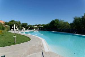 a large swimming pool in a yard with trees at Casa Antonella sul Golf in S'archittu Cuglieri