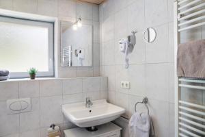 a white bathroom with a sink and a mirror at Ferienwohnung Mark in Biberwier +18 photos