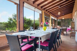 a dining room with a table and chairs and windows at Sa Vinyeta in Artá