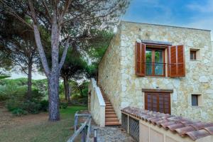 a stone building with a window and a staircase at Casa Antonella sul Golf in S'archittu Cuglieri