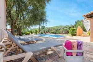 a couple of lounge chairs and a swimming pool at Sa Vinyeta in Artá