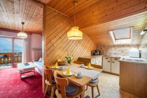 a kitchen and dining room with a table and chairs at Sankt Corbinian Apartement 4 in Caines
