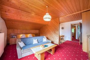 a living room with a blue couch and a table at Sankt Corbinian Apartement 4 in Caines
