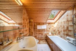 a bathroom with a large tub and a sink at Sankt Corbinian Apartement 4 in Caines