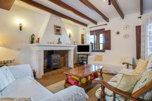 a living room with white furniture and a fireplace at Sa Vinyeta in Artá