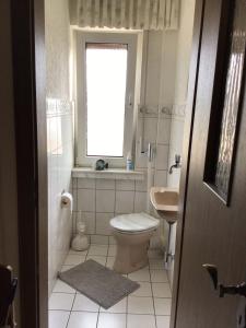 a bathroom with a toilet and a sink and a window at Balver Aussicht in Balve +3 photos