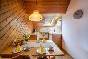 a dining room with a table and a kitchen at Sankt Corbinian Apartement 4 in Caines +12 photos