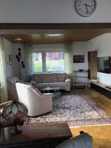 a living room with a couch and a clock on the wall at Balver Aussicht in Balve