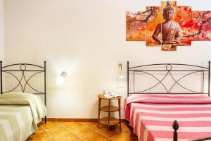 a bedroom with two beds and a painting on the wall at Bilo Anemone in Marina di Grosseto +25 photos