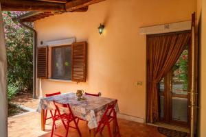 a dining room with a table and red chairs at Bilo Anemone in Marina di Grosseto