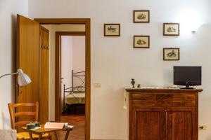 a room with a tv on a wooden dresser with a television on top at Bilo Anemone in Marina di Grosseto