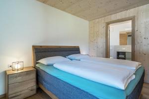 a bedroom with a large bed with a wooden headboard at Pixnerhof Chalet Natyra in Kastelbell-Tschars