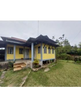 a small yellow house with a large yard at Andy homestay in Mawlynnong