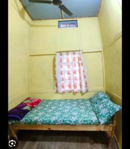 a small bed in a room with a window at Andy homestay in Mawlynnong