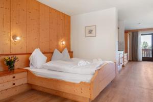 a bedroom with a large bed with a wooden wall at Aldeinerhof in Aldino