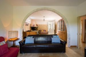 a living room with a leather couch and an archway at Villa Grazia in Gallipoli
