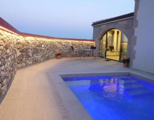 a backyard with a swimming pool and a stone wall at El Paller de Cal Maso in Guisona