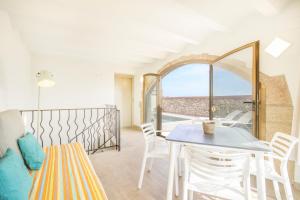 a living room with a table and chairs and a balcony at El Paller de Cal Maso in Guisona