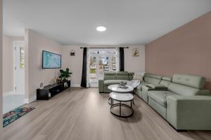 a living room with a couch and a table at Poolside Paradise minutes away from the Falls in Thorold