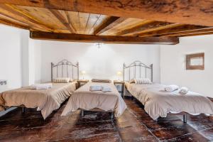 a group of four beds in a room at Casa Raymonde in Potes