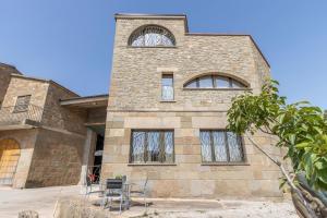a brick building with windows and chairs in front of it at El Paller de Cal Maso in Guisona