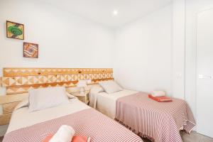 two beds in a room with white walls at El Paller de Cal Maso in Guisona