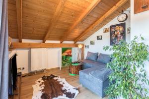 a living room with a blue couch and a wooden ceiling at Ferienwohnung Parzinger in Chieming
