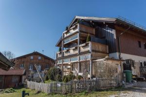 an old wooden house with a fence in front of it at Ferienwohnung Parzinger in Chieming