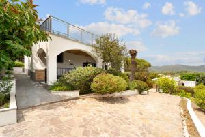 a house with a balcony and a walkway at Villa Matteo in Porto Columbu - Perdʼe Sali