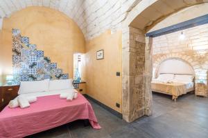 a bedroom with a bed with two beds in it at Dammuso 3cirniechi in Ragusa