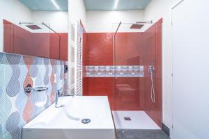 a bathroom with a shower and a white sink at Dammuso 3cirniechi in Ragusa