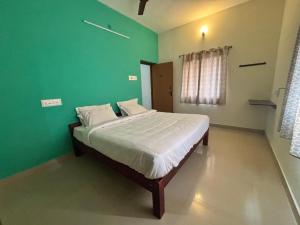a bedroom with a bed with a green wall at Thamira Residency Yercaud in Yercaud