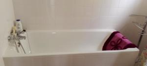 a white bath tub with a pink towel in it at Vivenda Chã in Ribeira Funda +13 photos