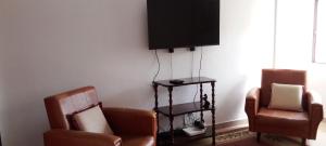 a living room with two chairs and a flat screen tv at Vivenda Chã in Ribeira Funda