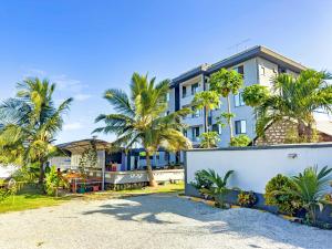 a building with palm trees in front of it at Diani Hideouts 2 in Kwale