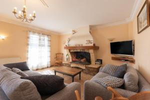 a living room with couches and a fire place at Gite Le Bérierot avec piscine in Ouzous