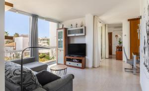 a living room with a couch and a television at Apartamento Llenaire cerca playa in Port de Pollensa