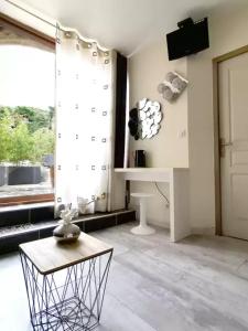 a living room with a table and a window at Chambres D'hôtes - Au Soleilo in Mostuéjouls