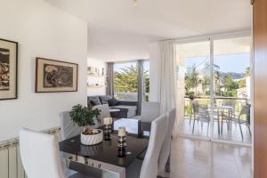 a dining room with a table and chairs and a living room at Apartamento Llenaire cerca playa in Port de Pollensa