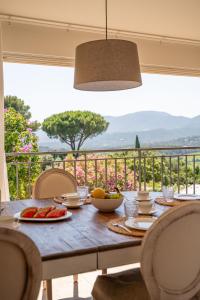 a wooden table with food on top of a balcony at Le Mas d'Aiguebelle in La Croix-Valmer