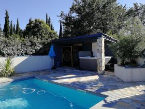 a swimming pool in a yard with a house at Gîte SPA Sauna Piscine in Grospierres