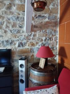 a lamp sitting on a barrel next to a room at Gîte SPA Sauna Piscine in Grospierres
