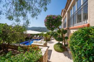 a house with a garden and a swimming pool at Le Mas d'Aiguebelle in La Croix-Valmer